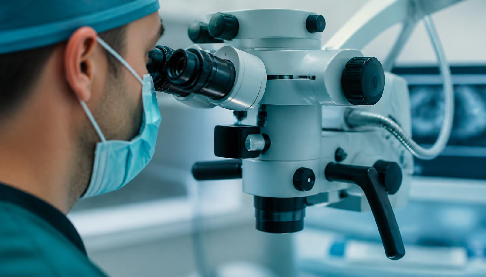 Especialista em endodontia trabalhando com microscópio odontológico